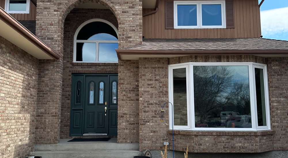 A new bay window installed on a brown brick house in Winnipeg, Manitoba.